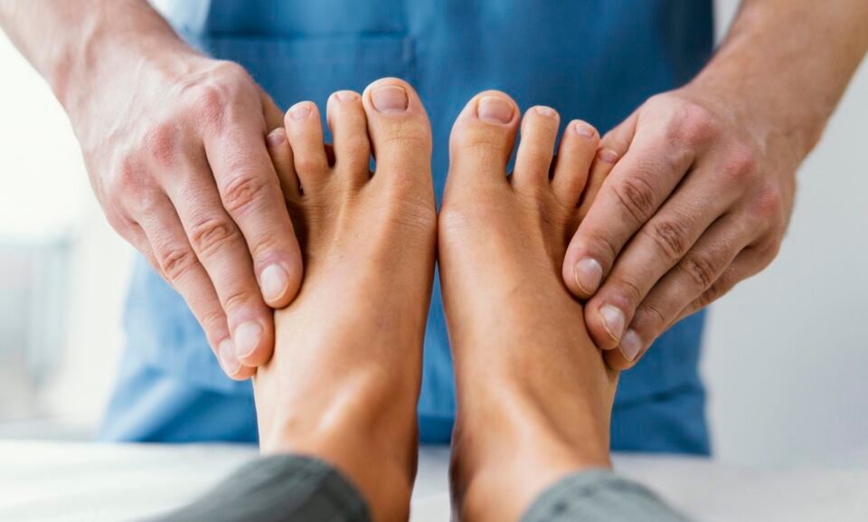 vista-frontal-del-terapeuta-osteopatico-masculino-comprobando-los-dedos-de-los-pies-del-paciente-femenino vista-frontal-del-terapeuta-osteopatico-masculino-comprobando-los-dedos-de-los-pies-del-paciente-femenino